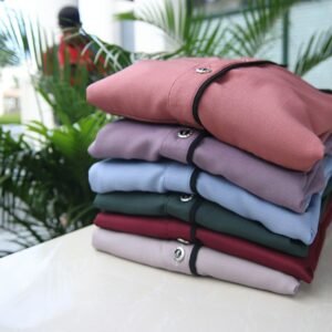 a stack of folded shirts sitting on top of a table